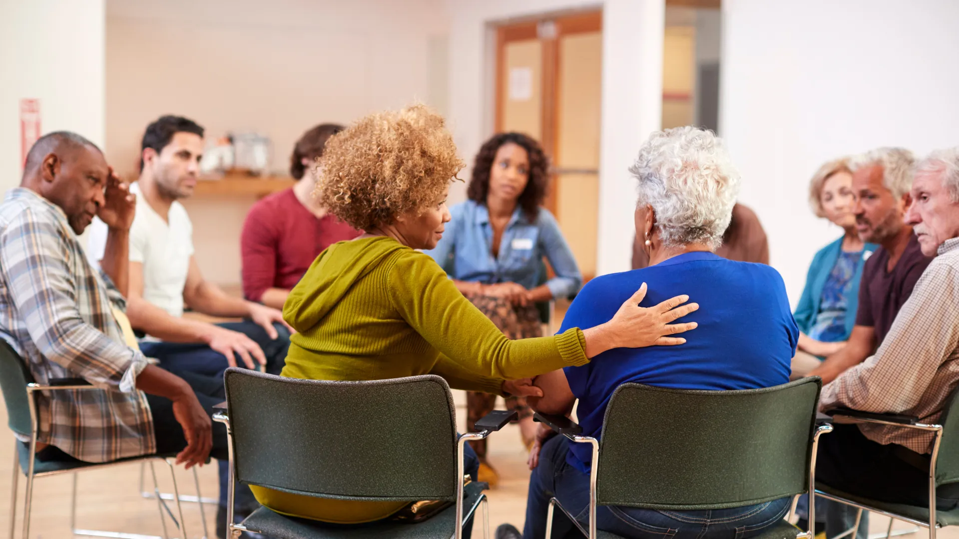 Group therapy session with diverse participants engaged in discussion in a supportive atmosphere.